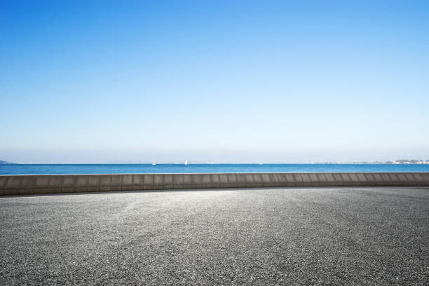istock empty asphalt road with blue sea in blue sky 875976846