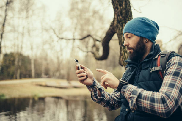 istock Man using a smart phone sitting in the park 875977398