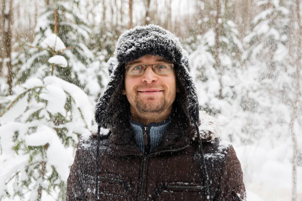 istock Man in fur winter hat with ear flaps smiling portrait 875980452