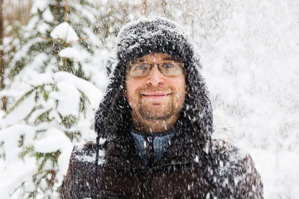 istock Man in fur winter hat with ear flaps smiling portrait 875980500