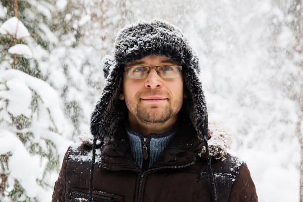 istock Man in fur winter hat with ear flaps smiling portrait 875980578