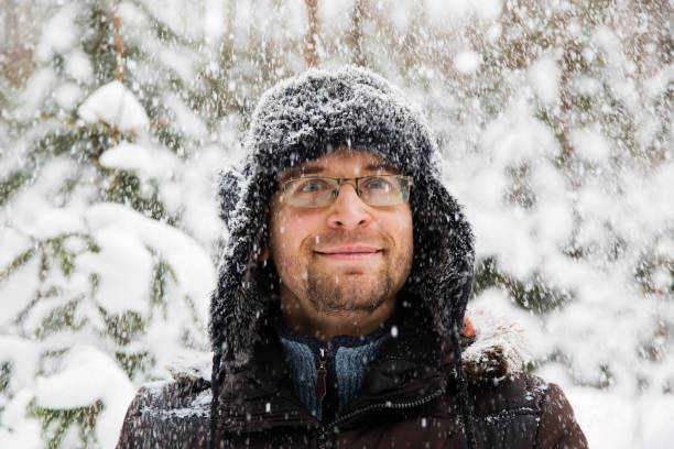 istock Man in fur winter hat with ear flaps smiling portrait 875980722
