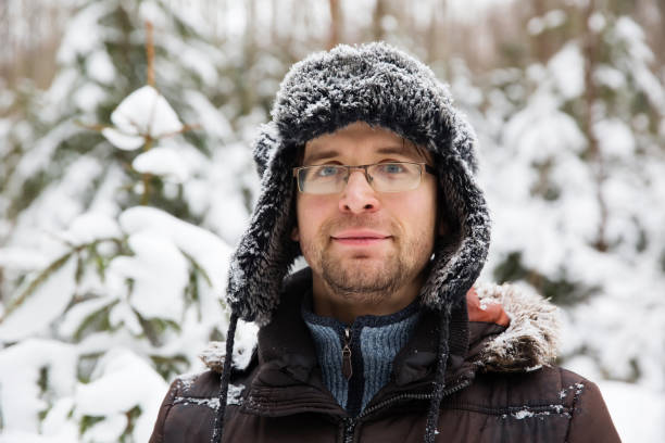 istock Man in fur winter hat with ear flaps smiling portrait 875981104