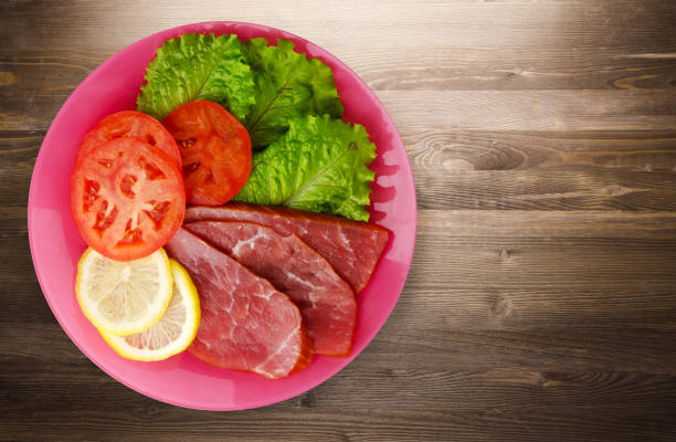 istock ham with salad, tomato and lemon on a plate. 875983818