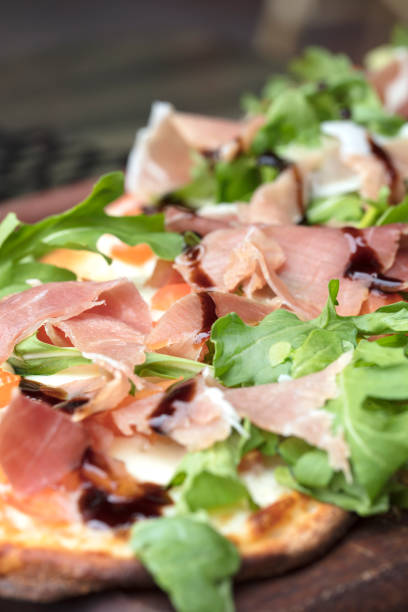istock Prosciutto, arugula and cheese flatbread dish baked until crispy and browned 875987320