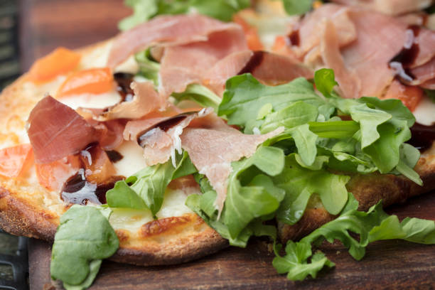 istock Prosciutto, arugula and cheese flatbread dish baked until crispy and browned 875987326