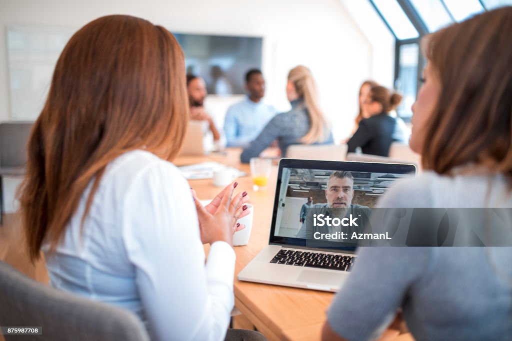 Video conference Business team having a meeting in an office. They are using laptop for video conference. Coworkers are having a discussion. Video Conference Stock Photo