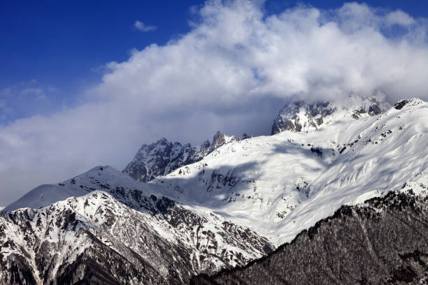 istock Snow mountains in clouds in winter sun day 875991772