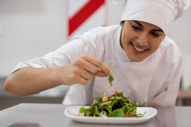 istock Beautiful main chef adding details to a salad she just prepared looking very happy and smiling 875991936