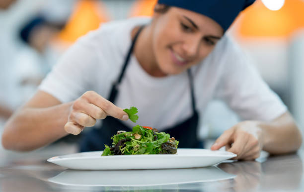 istock Happy female sous chef adding details to a delicious salad 875991978