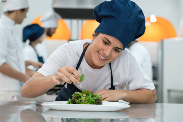 istock Cheerful sous chef adding details to a salad looking very happy and smiling 875992016