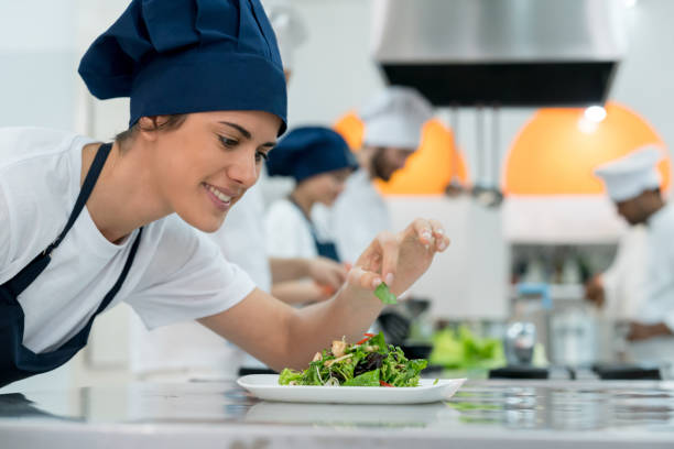 istock Happy female cook adding details to a salad she just prepared smiling 875992054