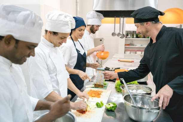 Students at a culinary institute learning how to cook and chef teaching them