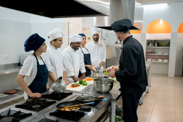 istock Multi ethnic group paying attention to the chef teacher at a cooking institute 875992132