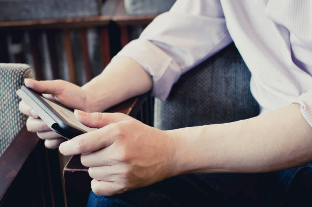 istock A man reading in the restaurant, holding an electronic reader in his hand. 875992384