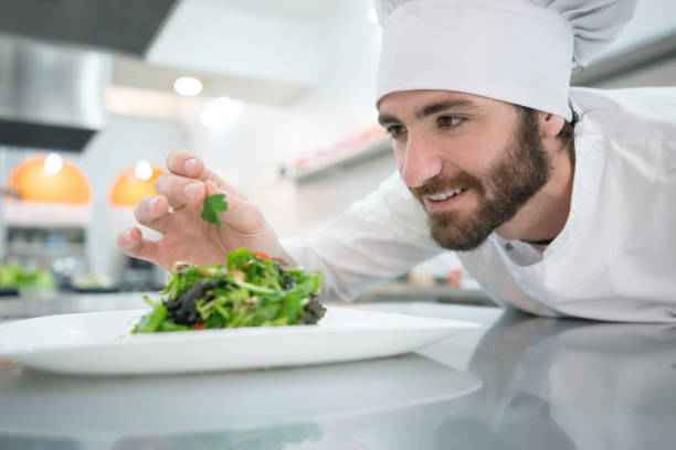 istock Handsome latin american chef adding details to a salad smiling 875992428