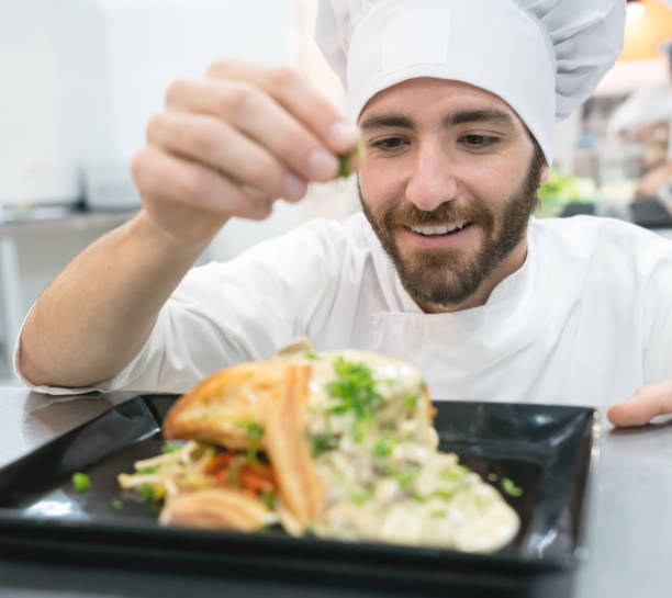 istock Cheerful young chef adding decorations to a plate he just finished 875992460