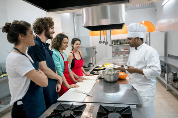 istock Happy couples at a cooking class with an indian chef all looking excited and smiling 875992468