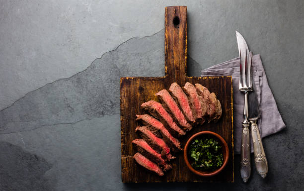 istock Mediun rare beef steak on wooden board. Top view 875992876