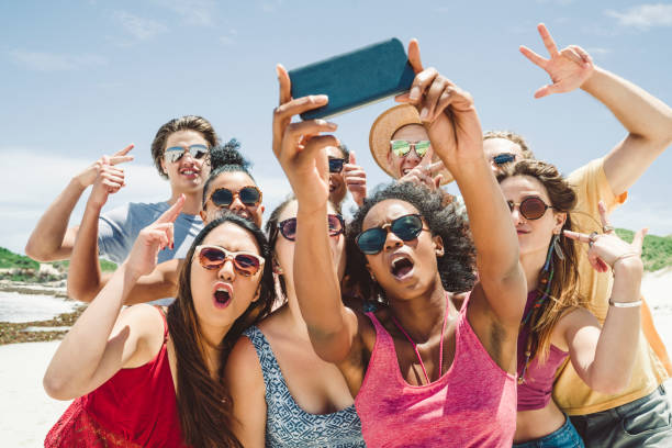 istock Friends taking selfie with smart phone at beach 875999912