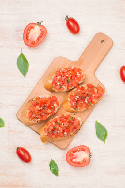 istock Italian bruschetta with roasted tomatoes, mozzarella cheese and herbs on a cutting board 876000130