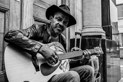 Port Louis, Mauritius, May 2, 2017: This old man is a street guitarist who is playing guitar outside Central Market of Port Louis.