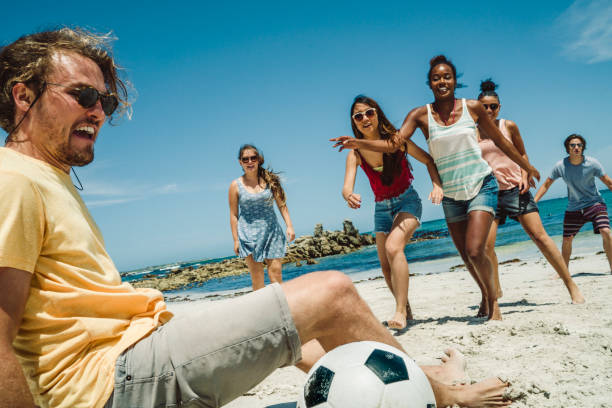 istock Multi-ethnic friends playing soccer at beach 876000710