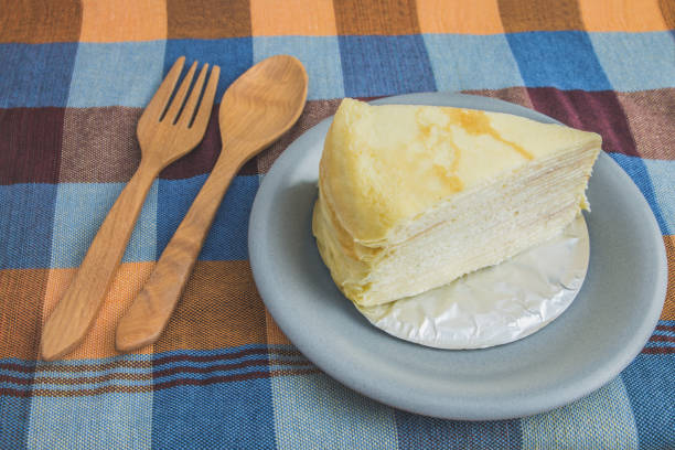 istock Crepe cake  or Milk cake in a plate with wooden spoon and fork 876000914