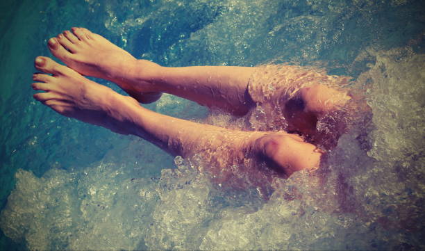 bare feet of a young woman during massage in the pool with vintage effect