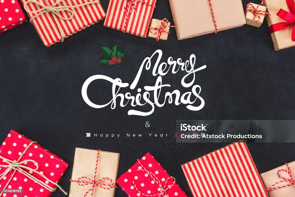 Christmas gift boxess on black background with new year wishes 2018 Colorful gift boxes on blackboard background with greeting texts Merry Christmas and Happy New Years 2018 Christmas Stock Photo