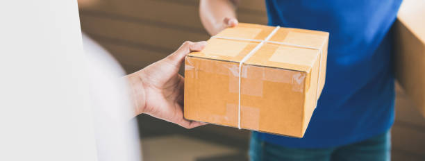 istock Delivery man handing a parcel over to a female customer 876018802