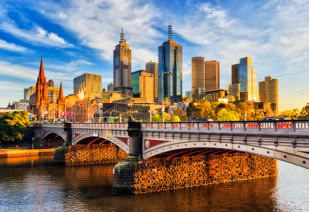 Me Princes Br Morning light Warm morning light on high-rise towers in Melbourne CBD above Princes bridge across Yarra river. melbourne australia stock pictures, royalty-free photos & images