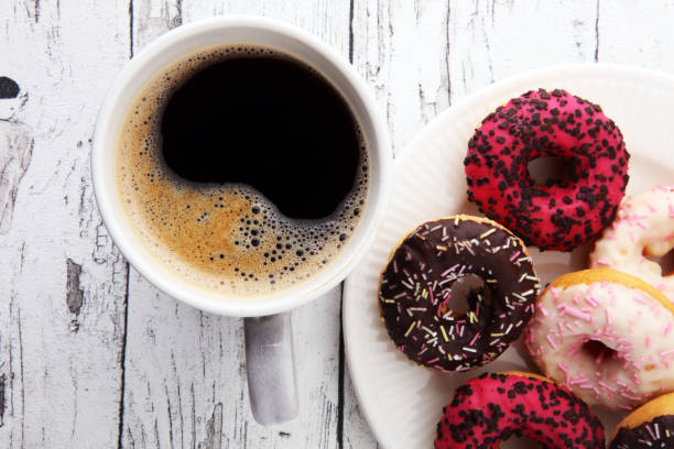 istock donuts and coffee for a sweet breakfast on wooden background 876030324