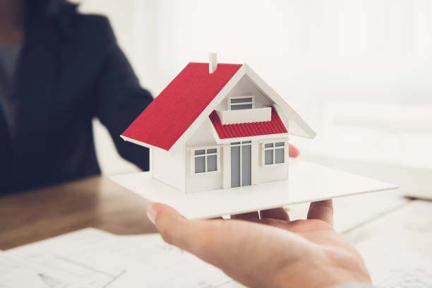 istock Real estate agent or architect presenting house model to client 876037390