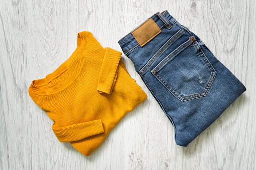Mustard sweater and jeans. Fashionable concept