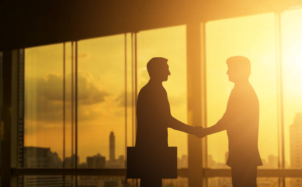 istock Second hand business hand in concept office silhouettes and successful business partner. 876040922