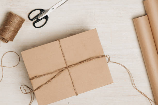 boîte en carton enveloppé de papier brun et ficelés - wrapped package string box photos et images de collection