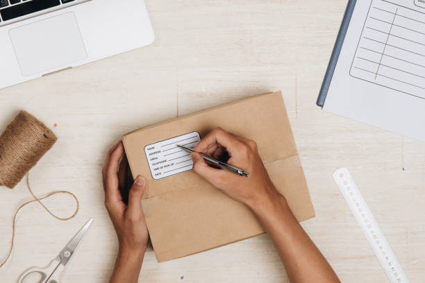 istock Top view of deliveryman making notes in delivery receipt at table 876042380