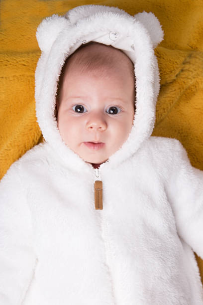 istock little baby in white bear costume on yellow blanket 876045182
