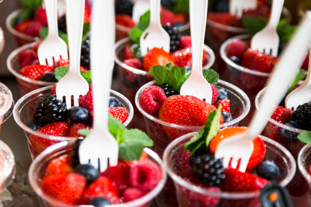 cierre de vasos de plástico en una fila llenado de fresas, frambuesas y moras - plastic knife fotografías e imágenes de stock