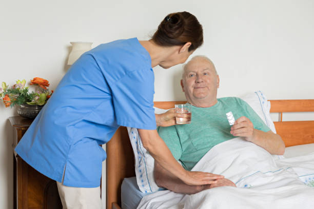 istock Caregiver and senior man in bed 876082504