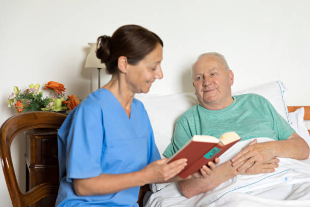 istock Caregiver and senior man in bed 876082518