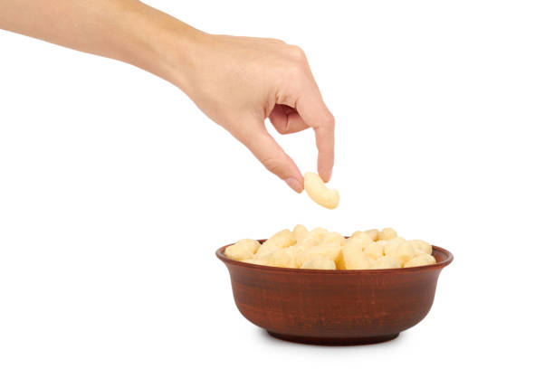 istock Light and delicious corn sticks in hand isolated on white background, healthy sweet snack 876089632