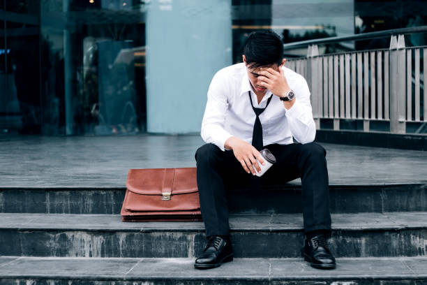 istock Unemployed Tired or stressed businessman sitting on the walkway after work Stressed businessman concept 876089768