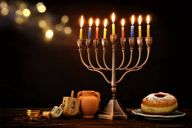 istock image of spinnig top, menorah (traditional candelabra) and burning candles 876095726