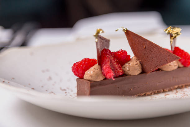 istock Chocolate dessert with raspberries and gold 876098510