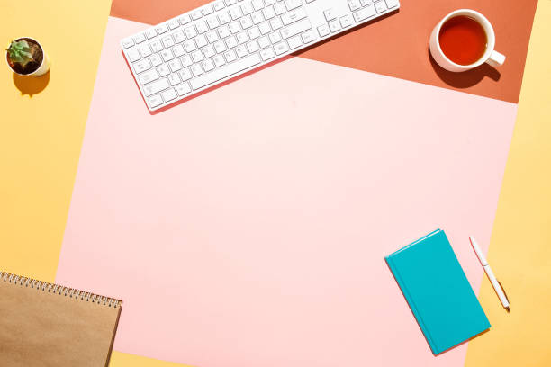 istock Trendy home office workspace. Flat lay composition of keyboard, cactus, diary with pen and cup of tea on colorful desk. Pink, yellow, aquamarine and and brown colours. Blogger's home office 876101974