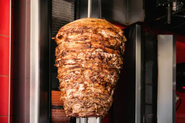 A close-up shot of delicious Doner kebab meat on a rotating vertical spit.