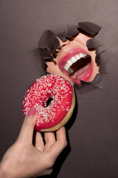 istock woman trying to bite donut 876129588