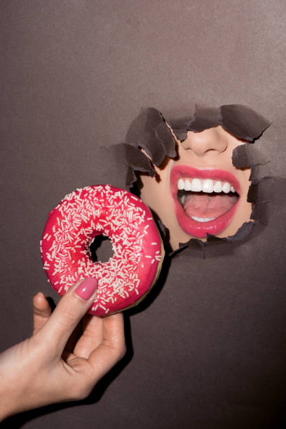 istock woman trying to bite donut 876129810